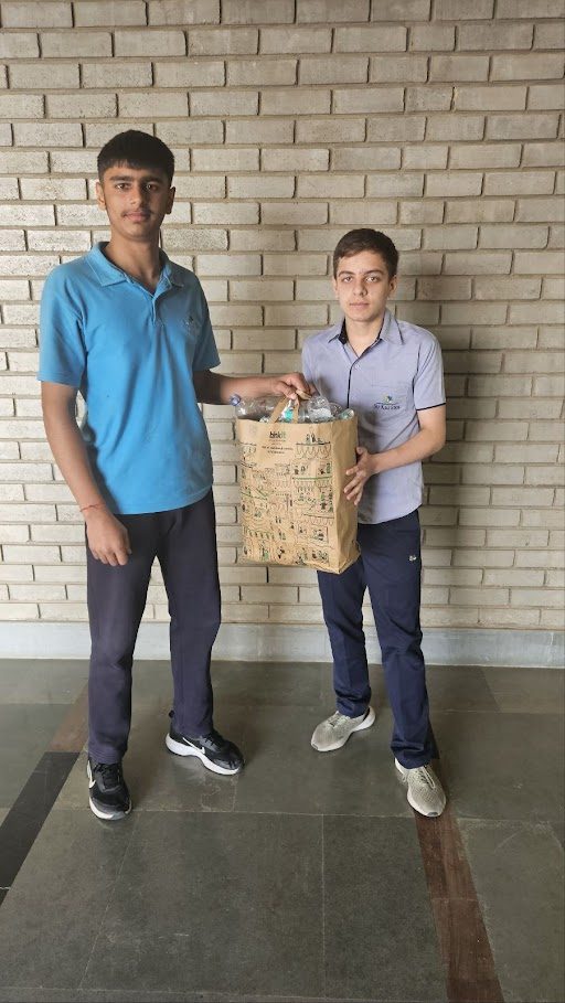 Students with a bag of plastic from the collection drive