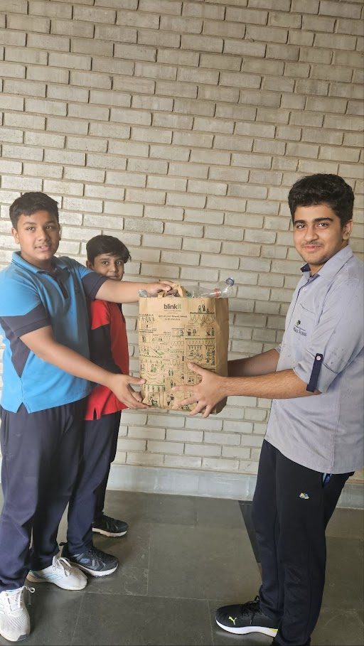 Students handing over collected plastic bottles and packaging
