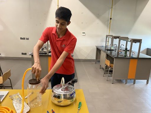 A student connecting the vapour pipe to the pressure cooker